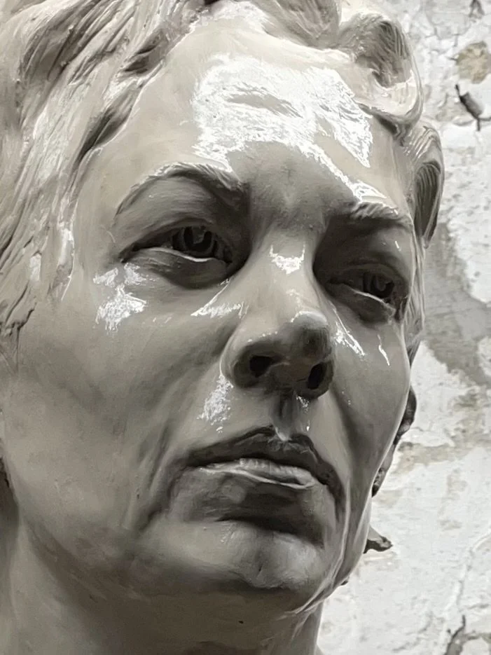 Close-up of a detailed clay sculpture of a person's face with an intense expression.