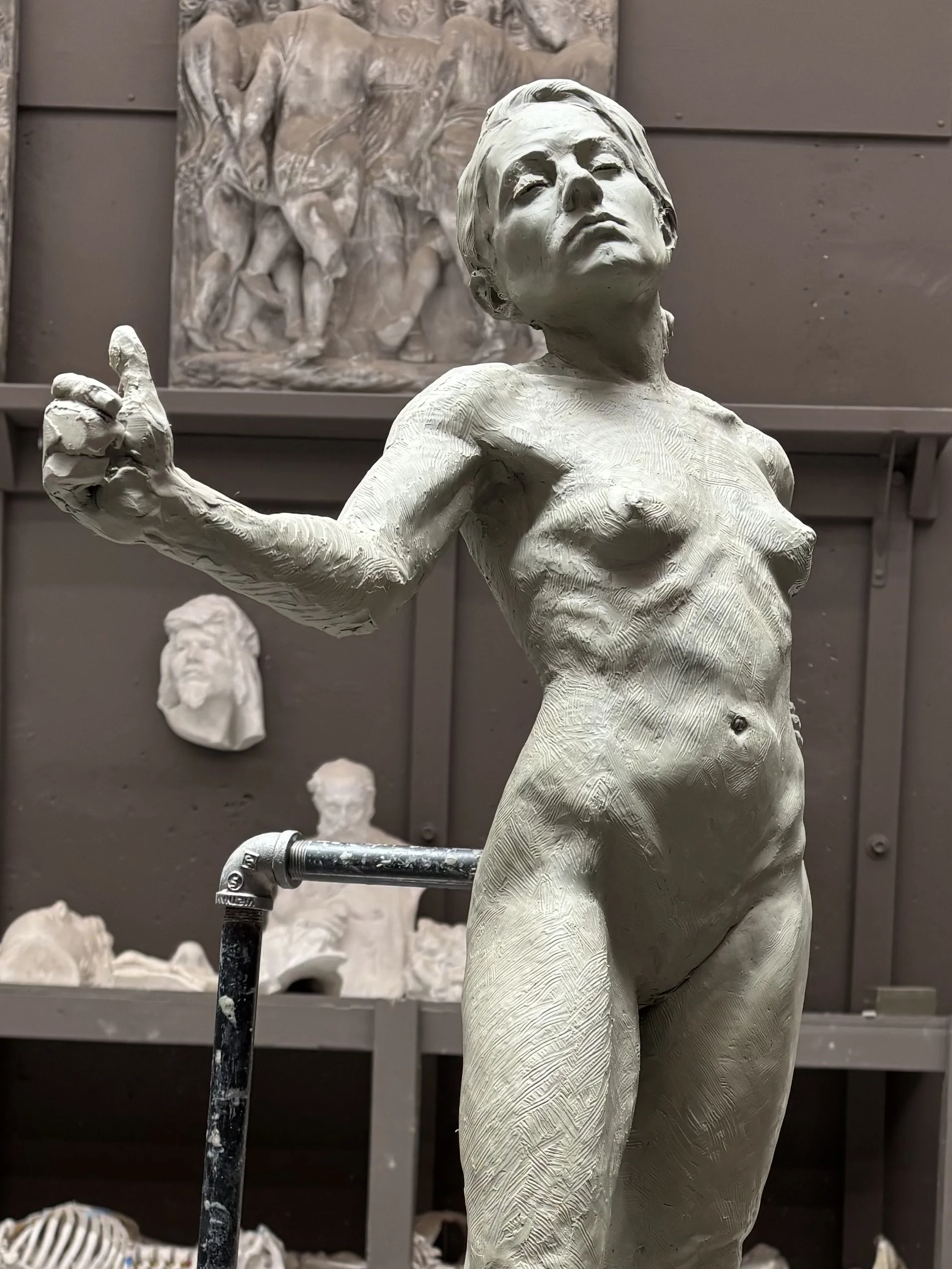 Un sculpture en arc blanc d'une femme avec les yeux fermés et bras levés