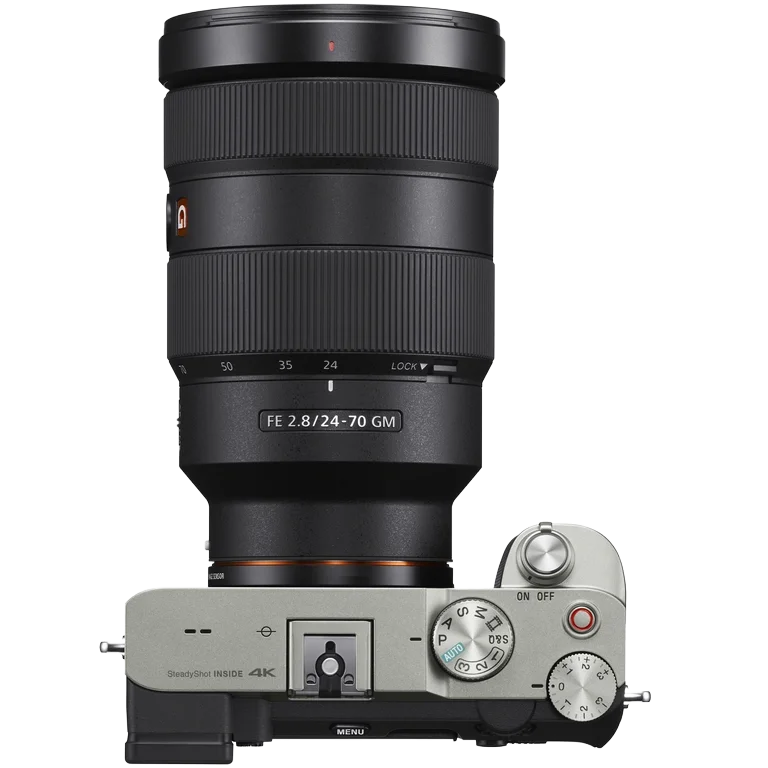 A digital camera with a large zoom lens attached, viewed from the top, showing mode dials, an ON/OFF switch, and a shutter button.
