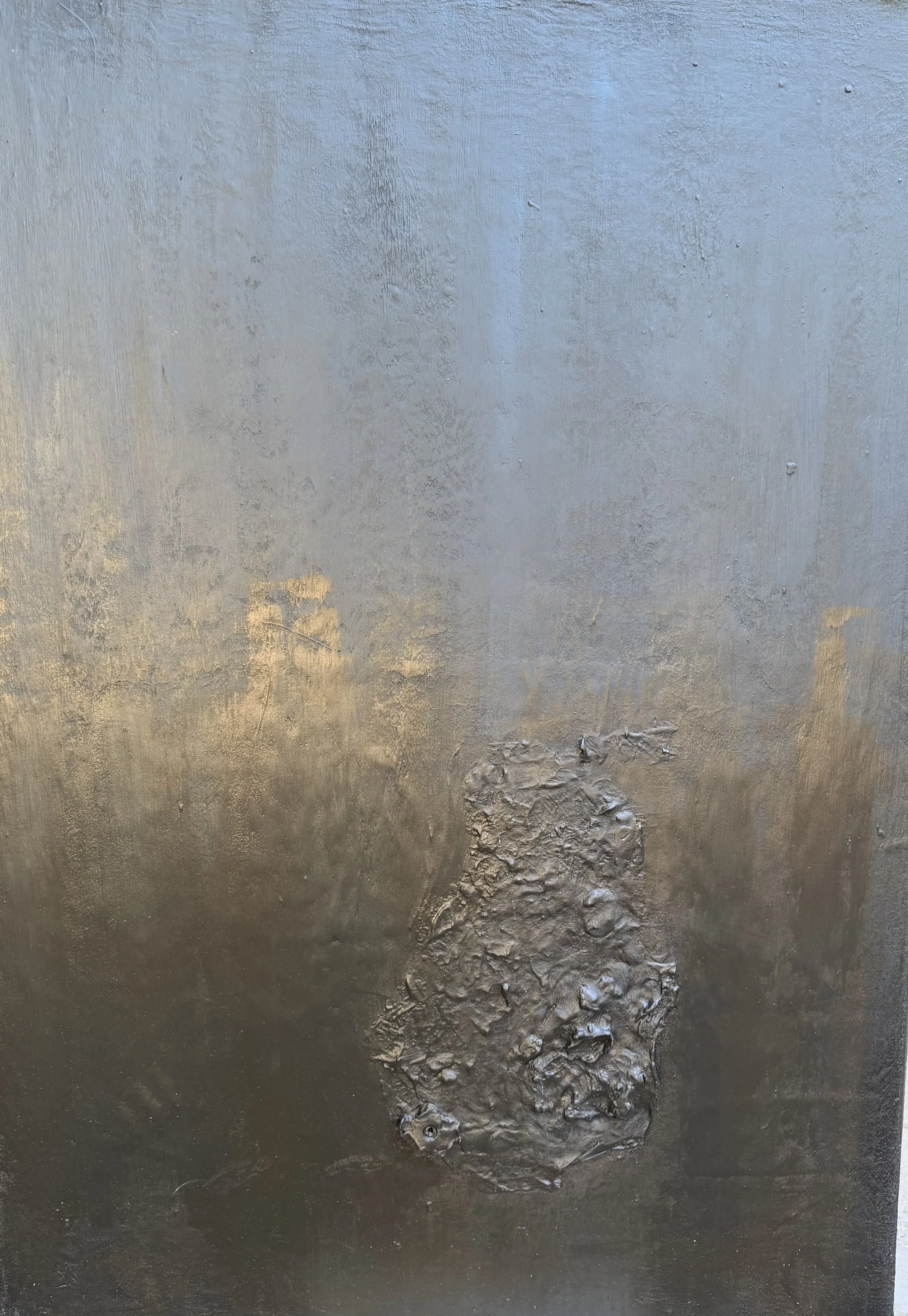 Close-up of a textured metallic surface with an irregular, raised patch of rough material
