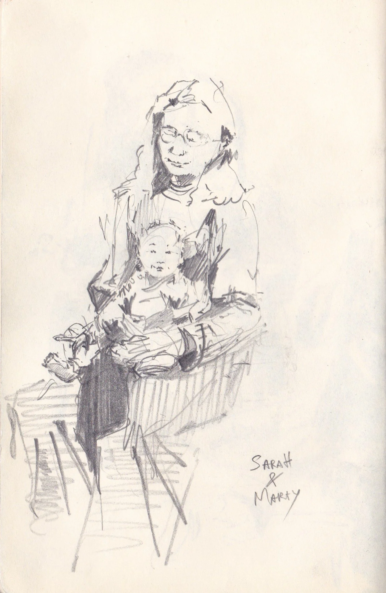 A black and white sketch of a woman with glasses and long hair, sitting at a table with a child on her lap. The woman is resting her head on one hand, and the child has cat ears drawn on their head. The sketch is signed 'Sarah & Marty' in the bottom 