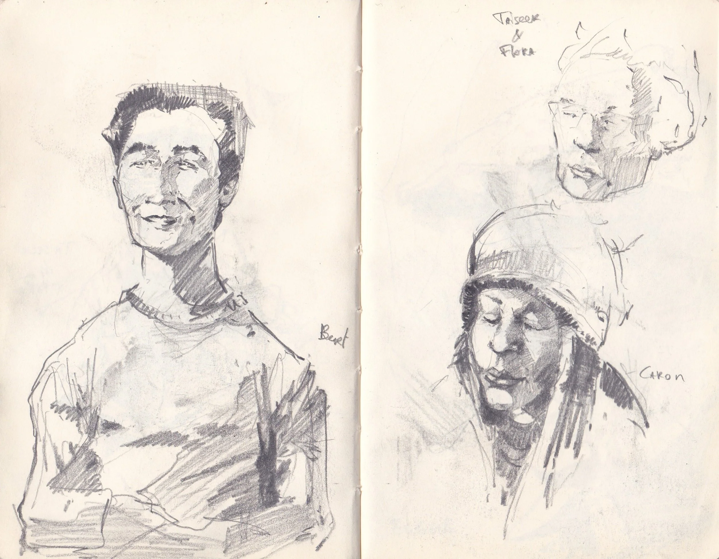 Two black and white sketches of people on a two-page spread in a sketchbook. The left sketch depicts a woman with short hair, wearing a top with a detailed neckline, smiling and looking slightly to her right. The right sketch shows a woman with glass