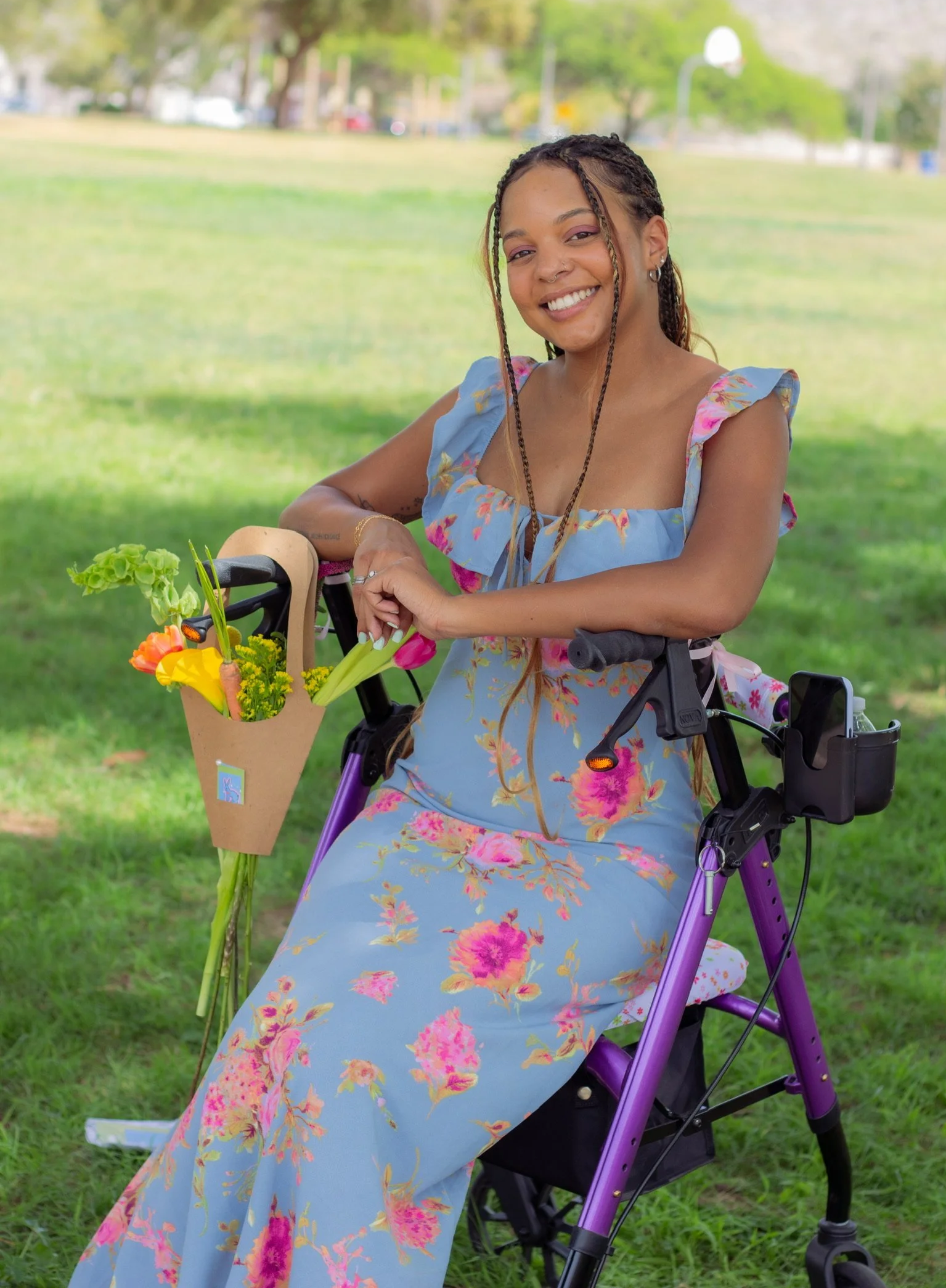 Founder, Santana sitting in her mobility device smiling