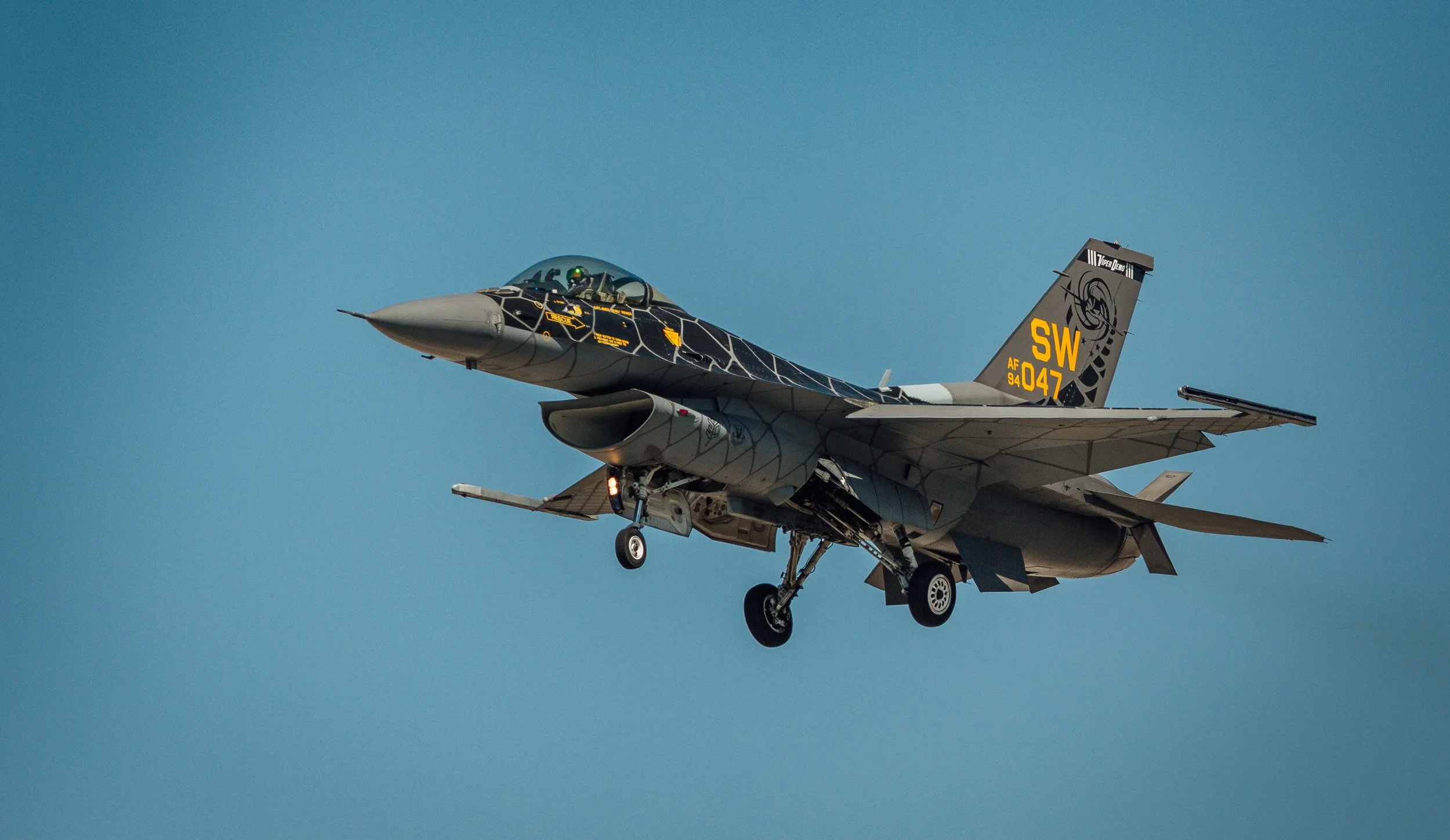 A fighter jet aircraft flying against a clear blue sky.