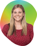 A woman with long blonde hair smiling, wearing a red polka dot blouse, against a colorful gradient background.