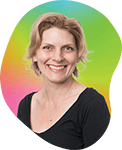 Smiling woman with short blonde hair wearing a black top, against a colorful background with green and pink hues.