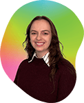 Portrait of a young woman with long wavy brown hair, wearing a maroon sweater, smiling against a green and pink gradient background.