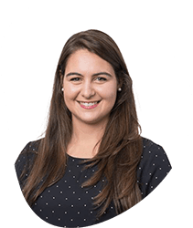 A woman with long brown hair smiling, wearing a black polka dot top, against a white background.