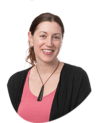 A woman with brown hair in a ponytail, wearing a black cardigan over a pink top, smiling against a white background.