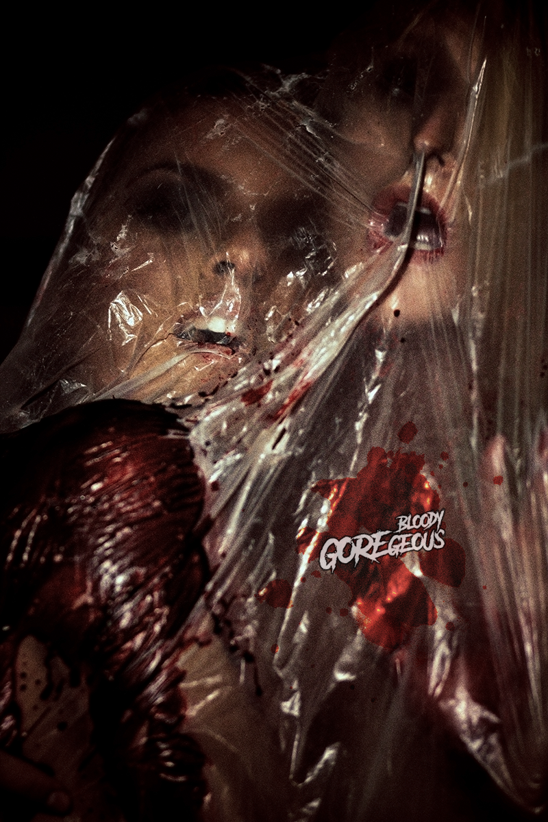 A woman with red lipstick behind a torn plastic sheet with blood splatters, holding a dark object, and the words 'Bloody GORETIOUS' written on the sheet.