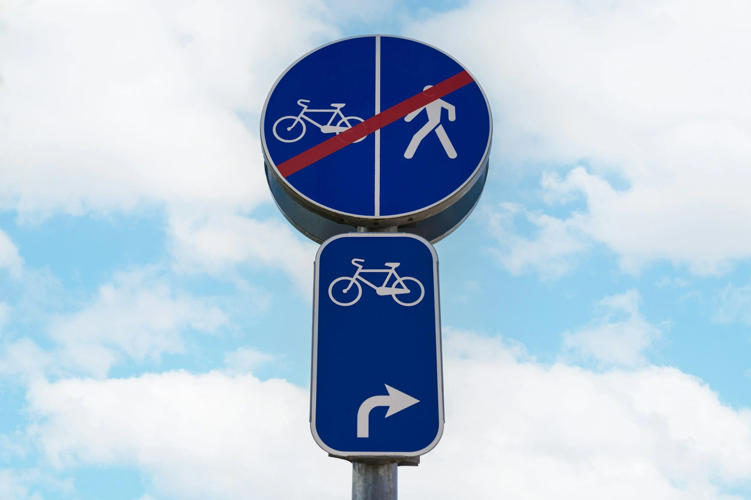 Traffic sign indicating no bicycles or pedestrians allowed, with a sign below showing a bicycle and arrow pointing to the right.