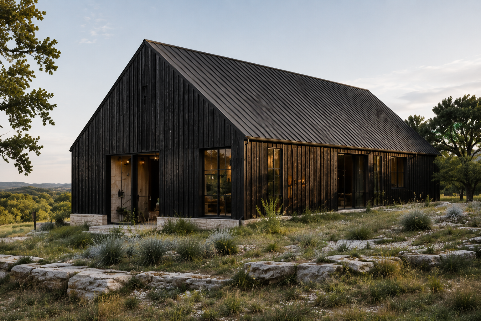 Black timber-clad residence with a pitched metal roof and native Hill Country landscaping.