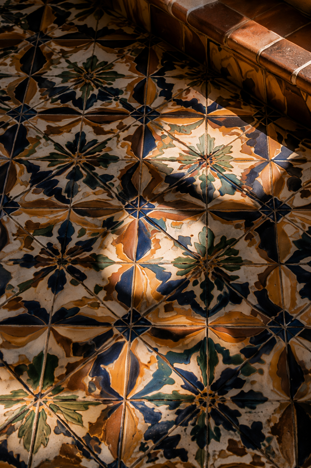 Decorative hand-painted tiles with blue, terracotta, and cream floral patterns.