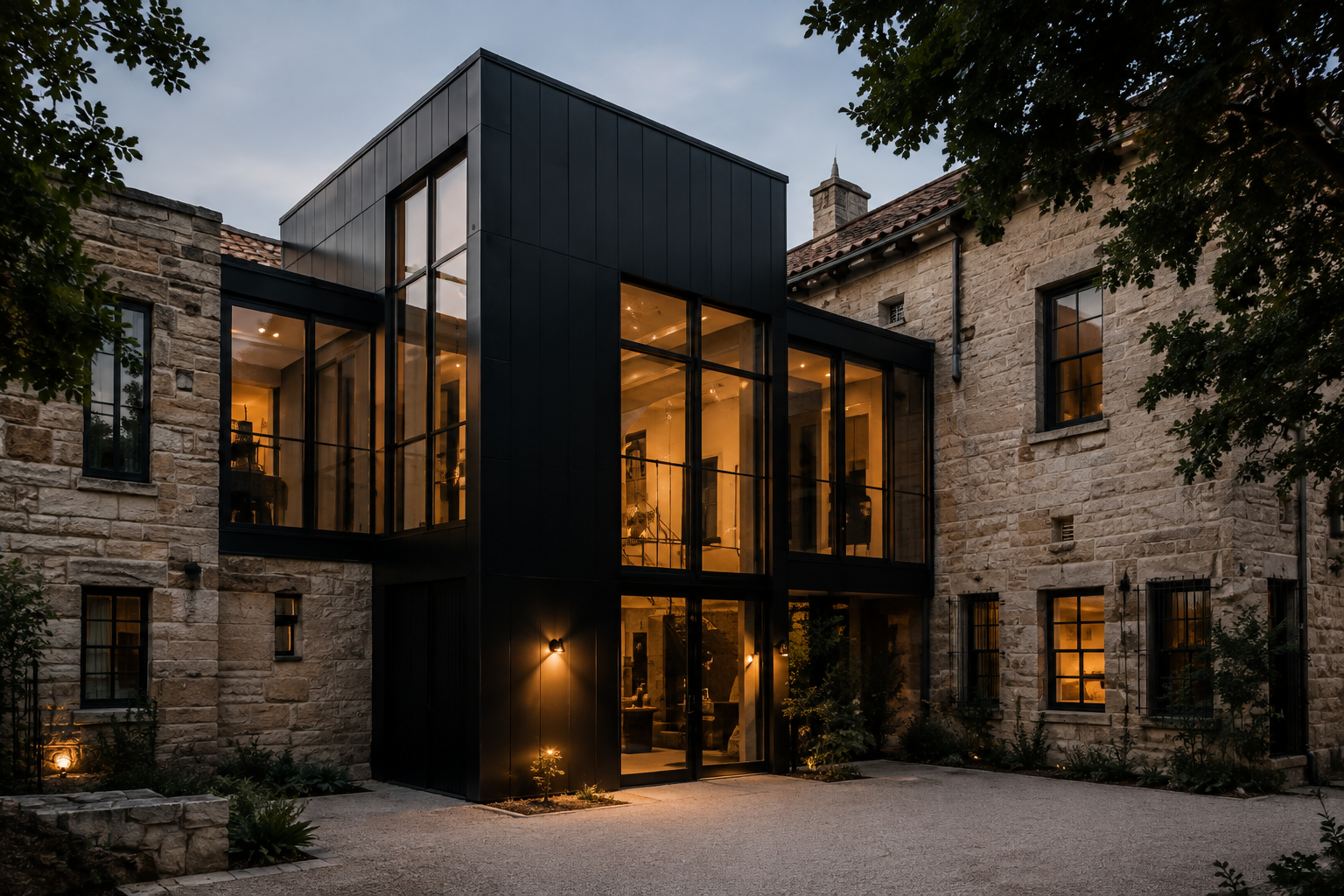 Contemporary black steel and glass addition adjoining a traditional limestone residence.