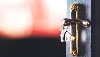 Door handle with inserted keys on blurred background