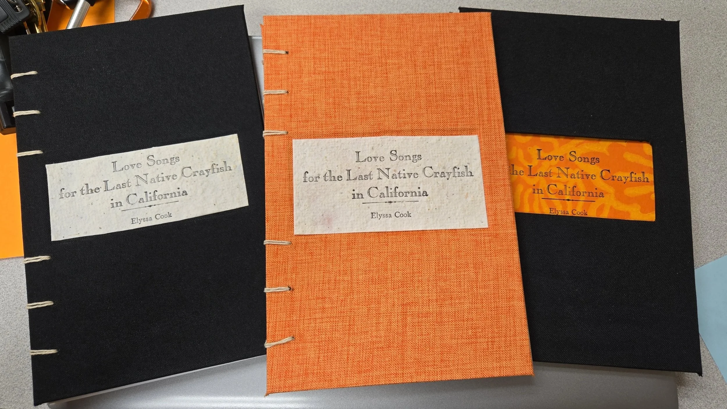 Three orange & black coptic-bound books