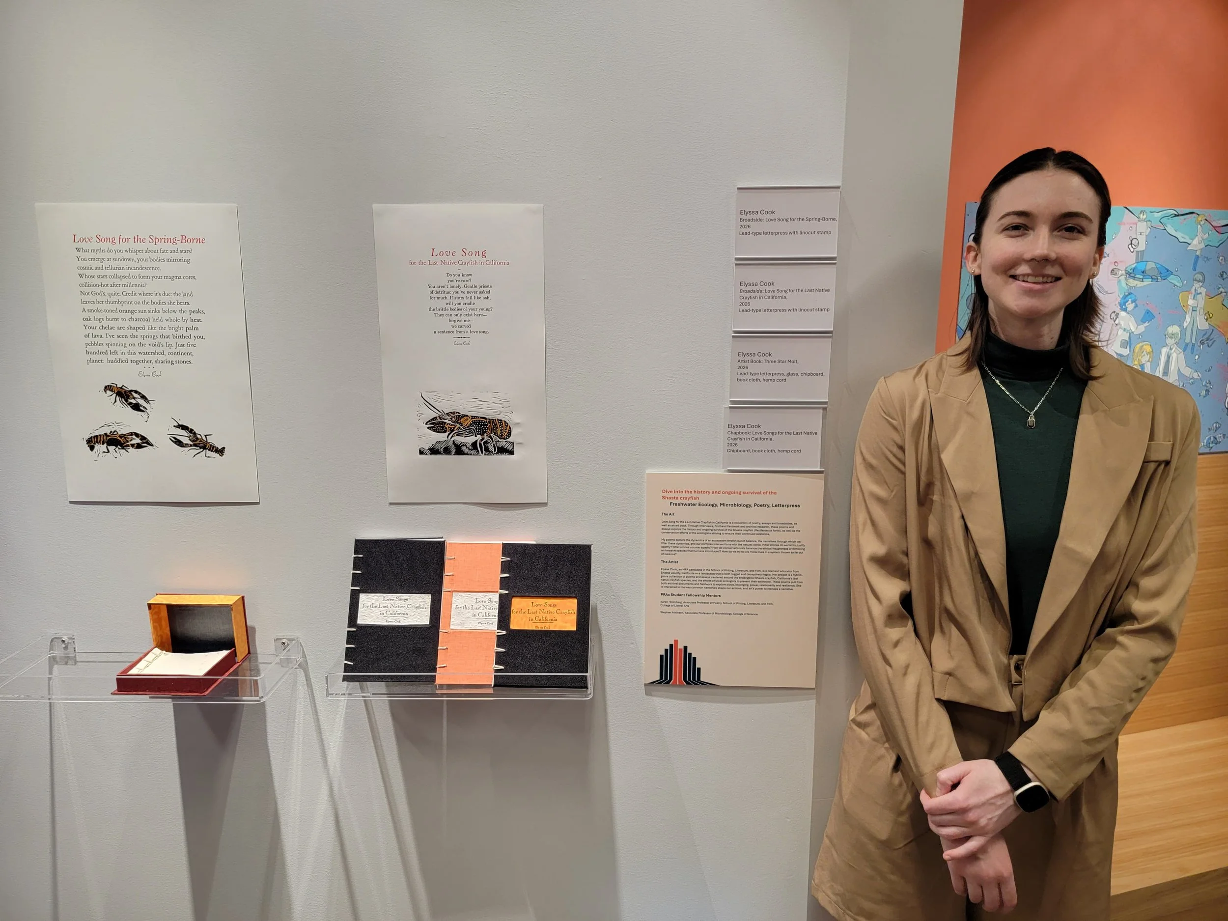 Elyssa Standing in front of four books, two broadsides, and a museum description plate