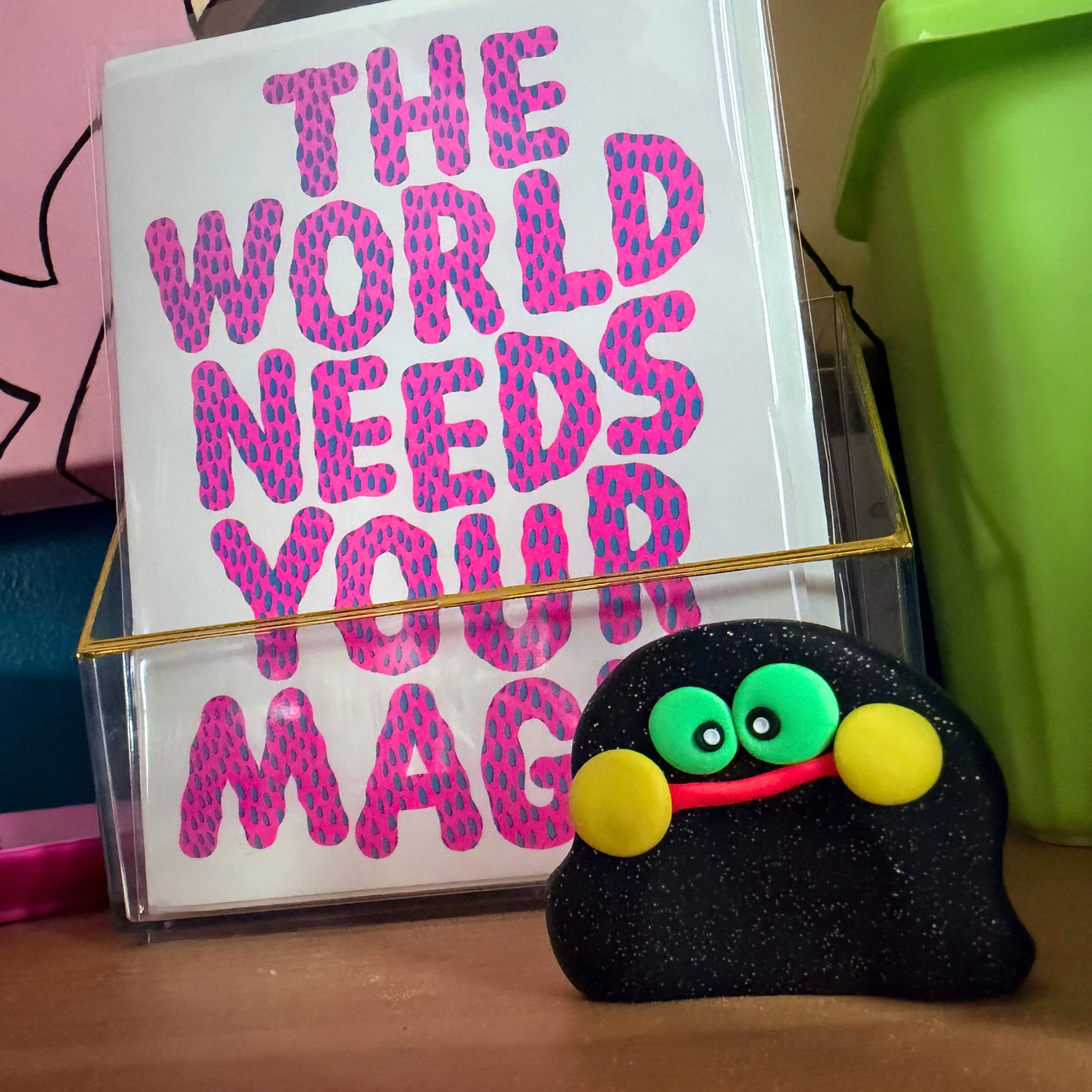 Pixel Blobert worry stone standing on desk.