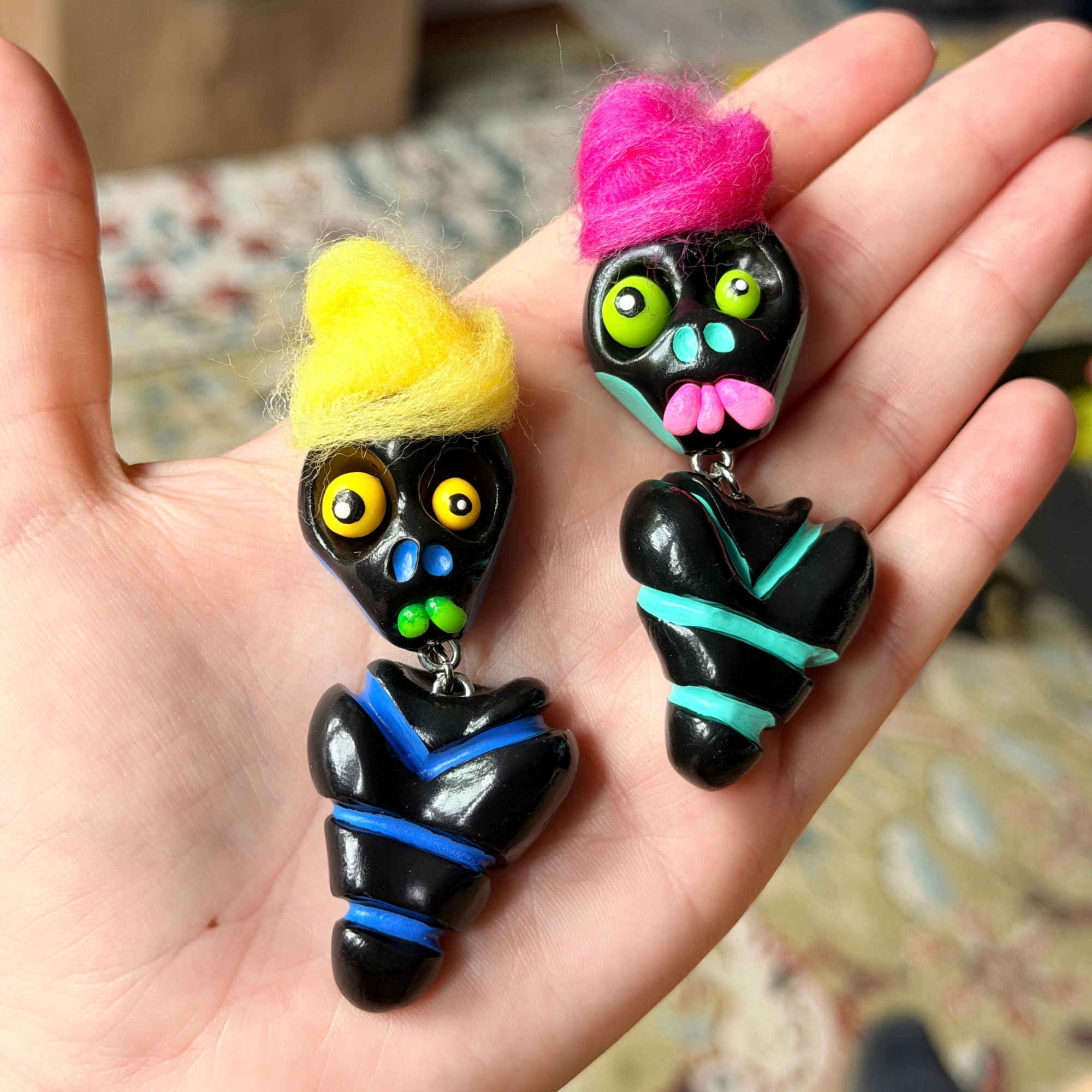 Two black bone daddy fidgets photographed in hand with their hair tied into a bun.