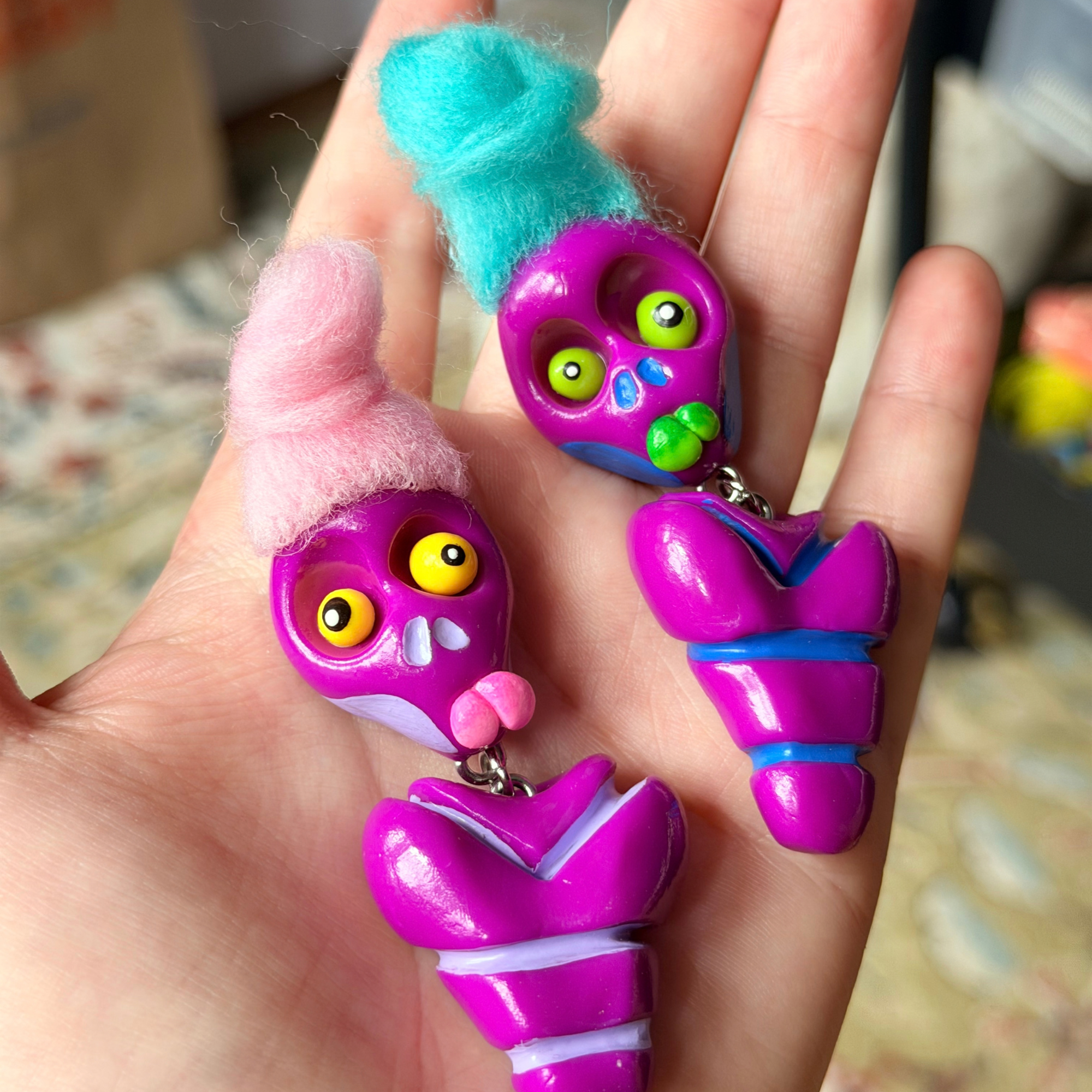 Two purple bone daddy fidgets photographed in hand.