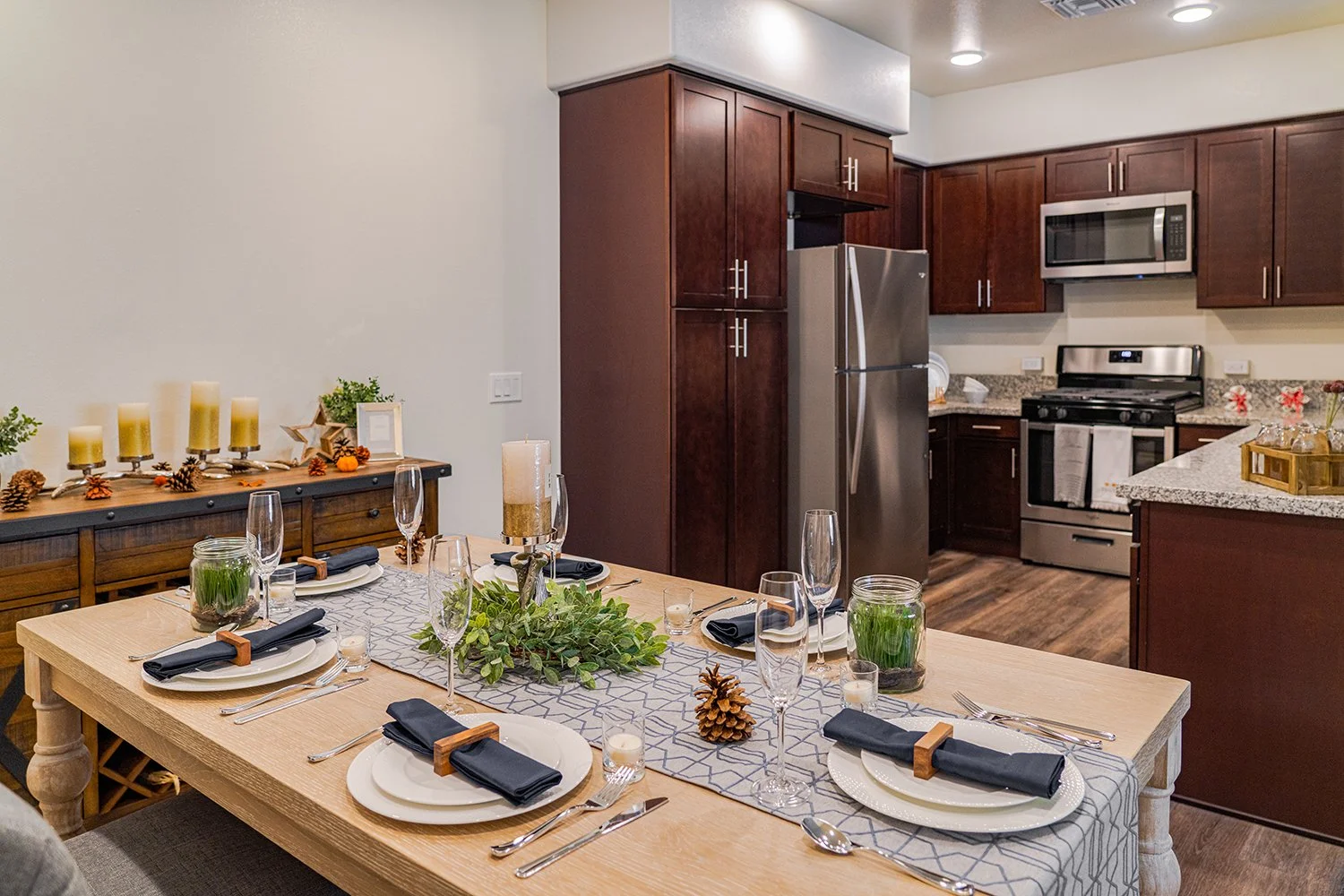 Dining nook off to the side of the state-of-the-art kitchen in Turtle Creek Apartment home with wood-style plank flooring and a charming window. 