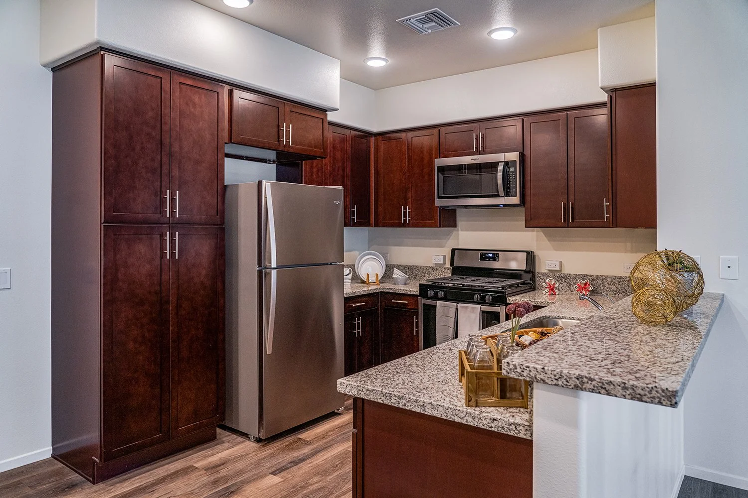 Gorgeous updated kitchen in Turtle Creek apartment home with granite countertops, dark wood shaker cabinets, and stainless steel appliances. 