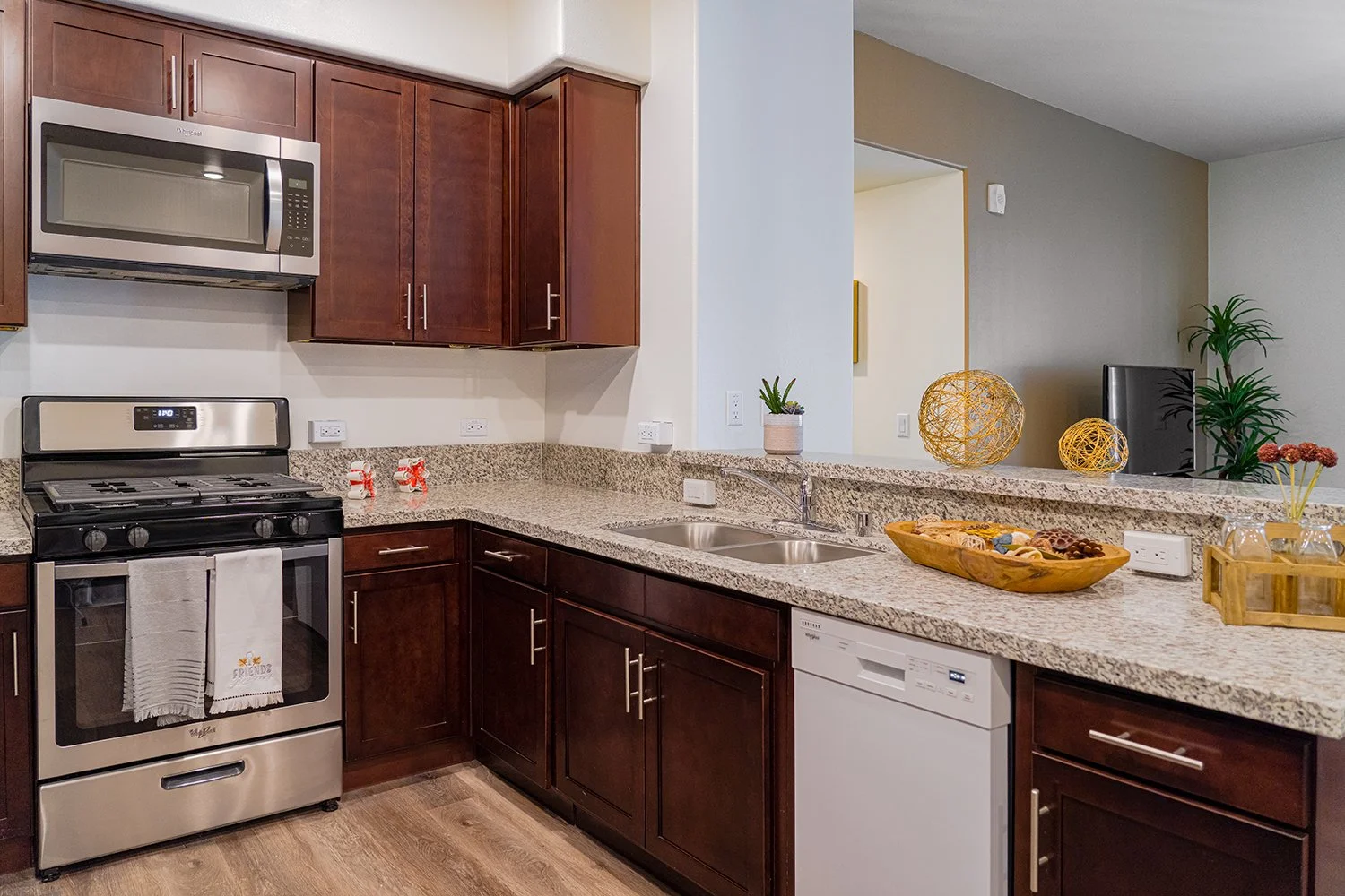 Gorgeous updated kitchen in Turtle Creek apartment home with granite countertops, dark wood shaker cabinets, and stainless steel appliances. 