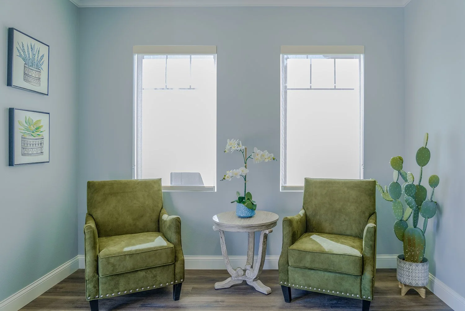 Comfortable seating area in Turtle creek leasing office with two accent chairs in a nook with large windows allowing for gorgeous natural lighting. 