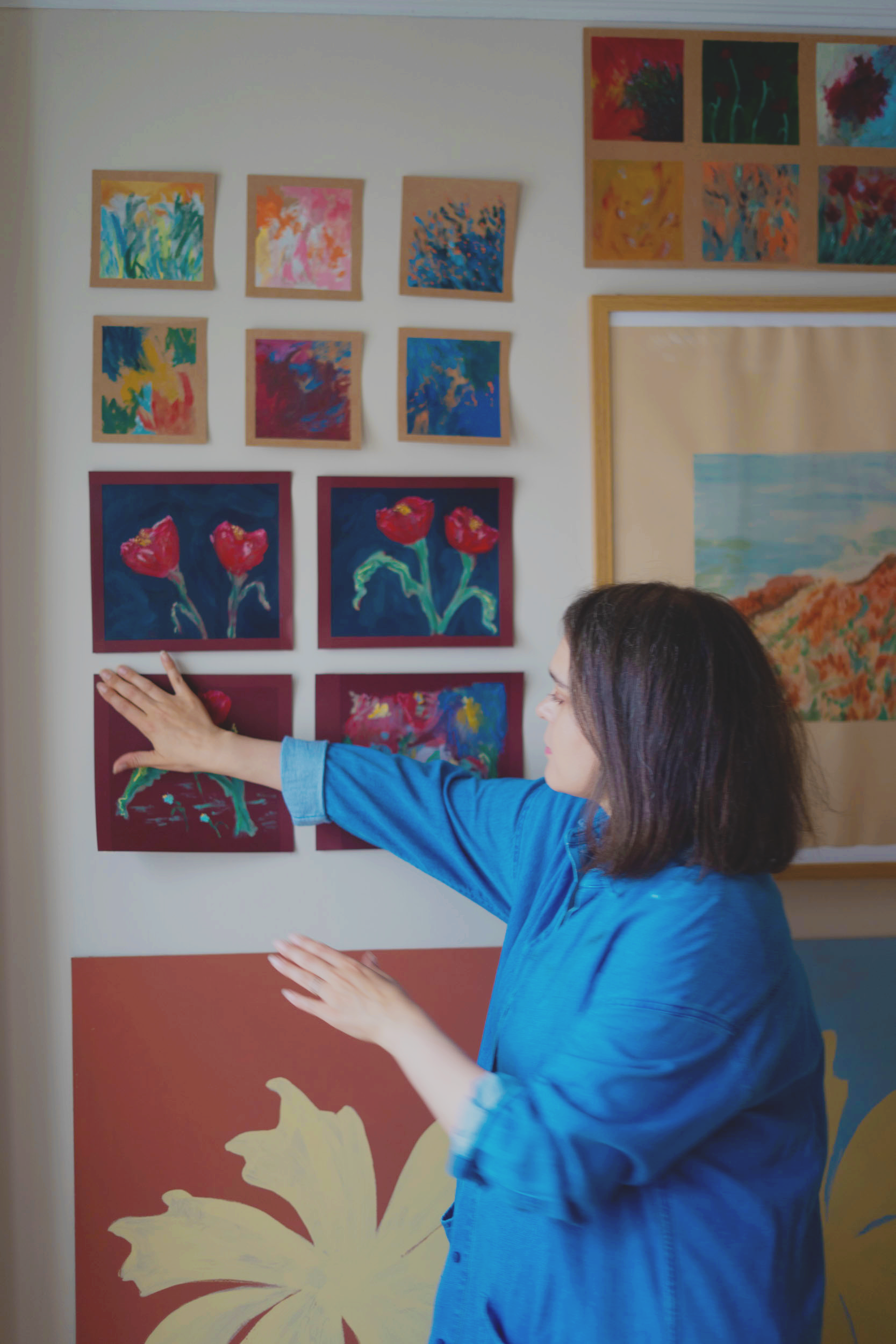 a photograph of artist emily of studio lawen and her paintings