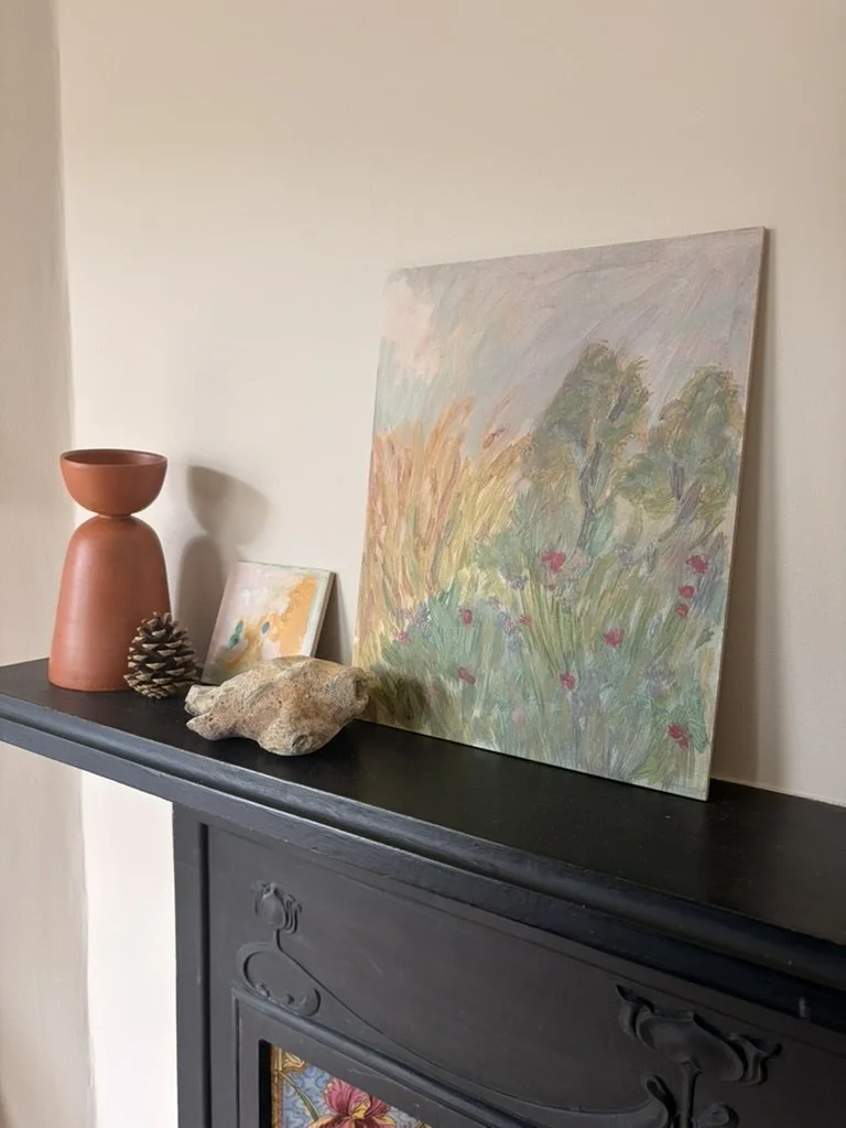 painting of a landscape on board on a mantelpiece