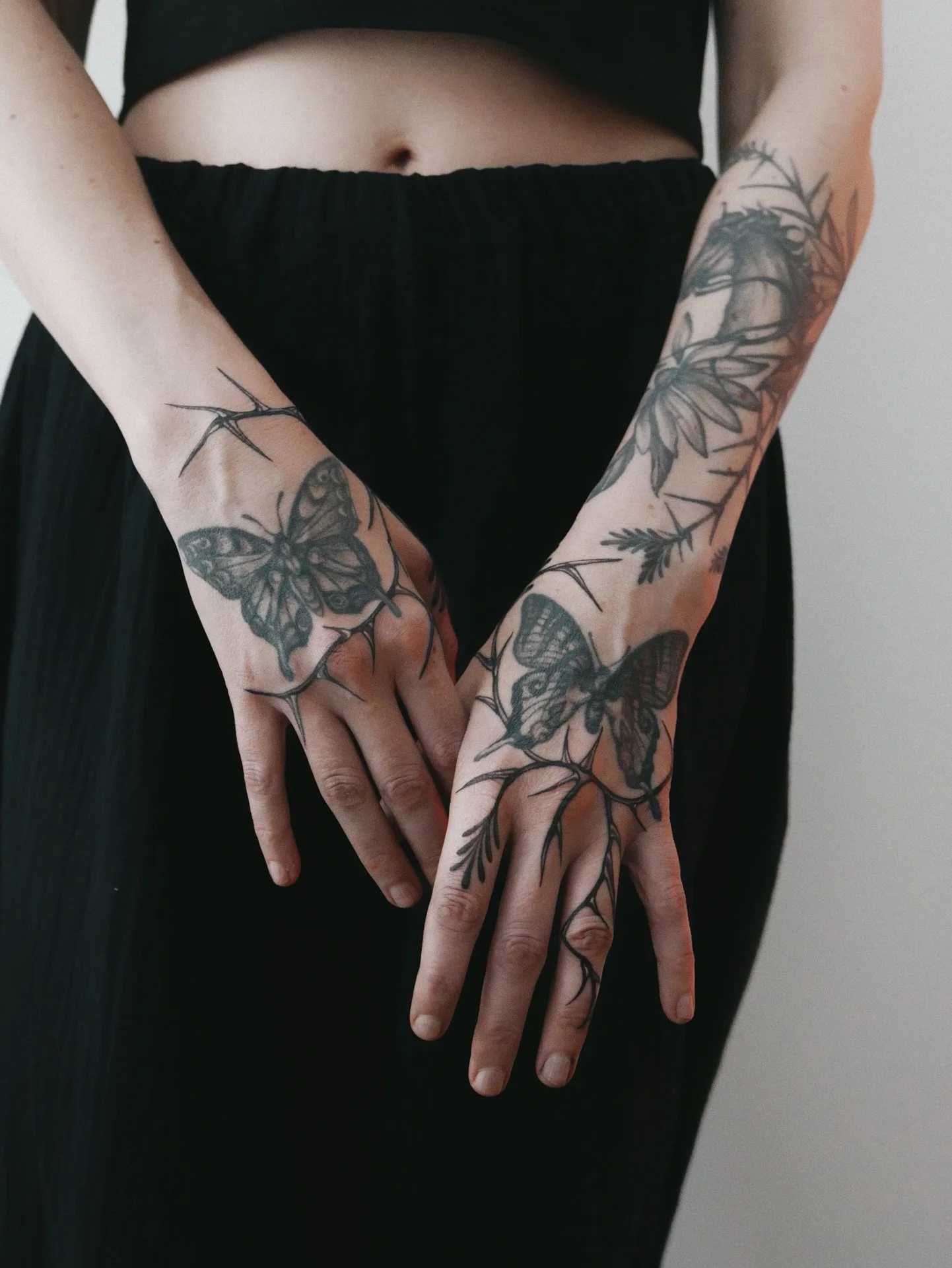 blackwork botanical thorns and butterflies on hands and forearms