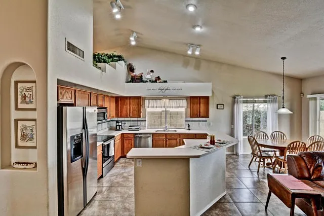 Outdated honey oak Phoenix kitchen with tile floor and peninsula counter before open concept remodel
