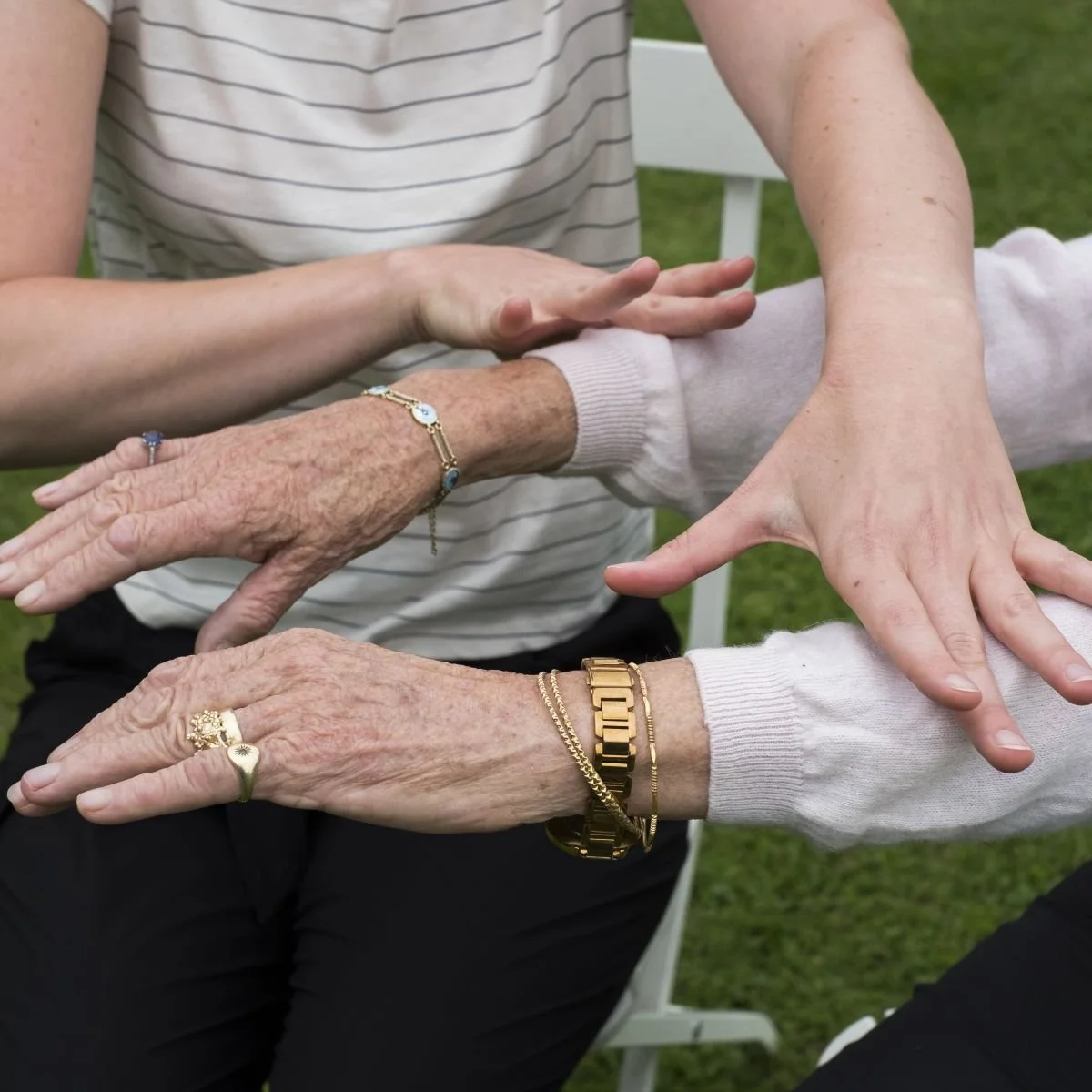 Woman holding hands over a woman's outstretched arms.