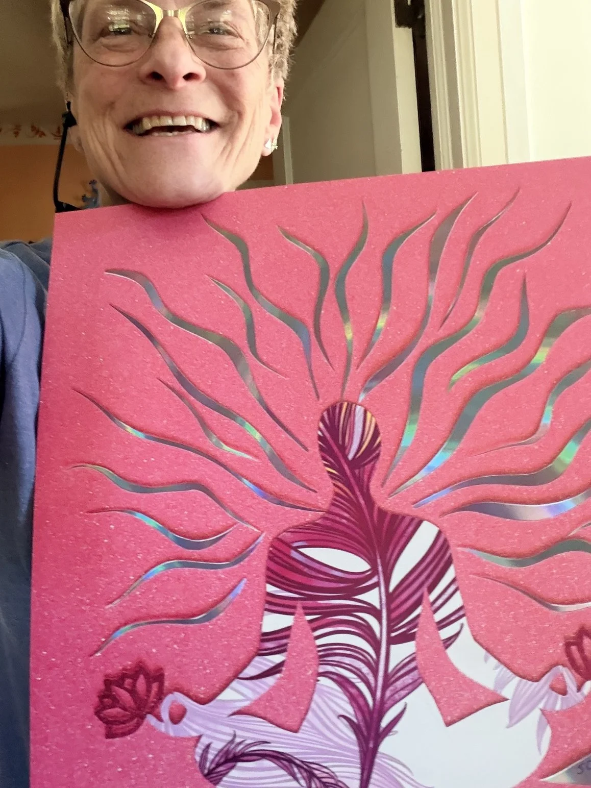 Artist Jodi Carlson holding 'Radiant Energy,' a hand-cut paper collage from her Lotus Series