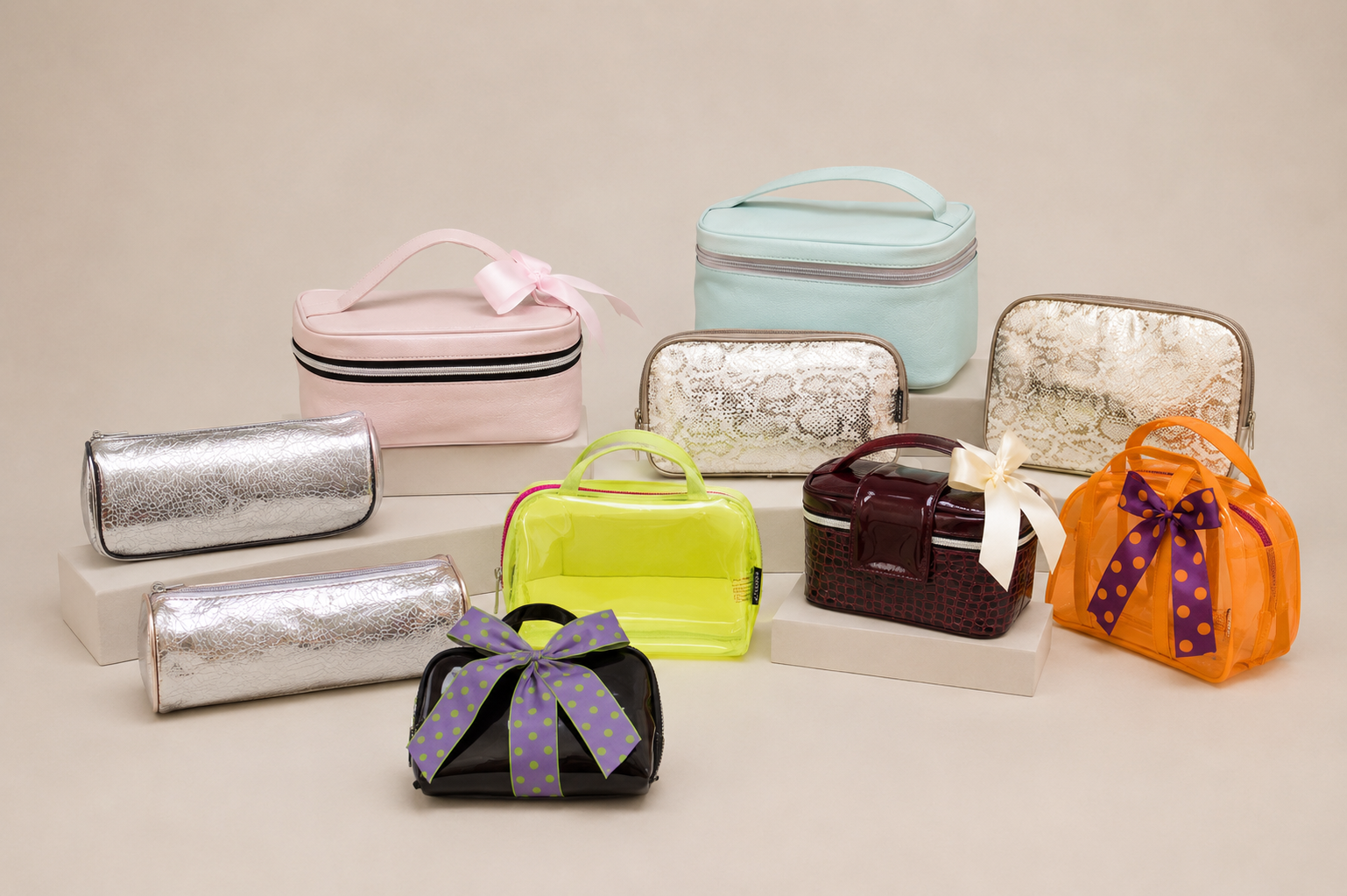 Varias bolsas de maquillaje y bolsos decorativos en colores pastel, plateados, neón, y con lazos en un fondo beige.