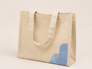 Bolsa de tela cremosa con diseño de formas azules en una esquina.