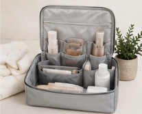 Maletín de viaje gris con productos de cuidado personal y una planta en una maceta beige.