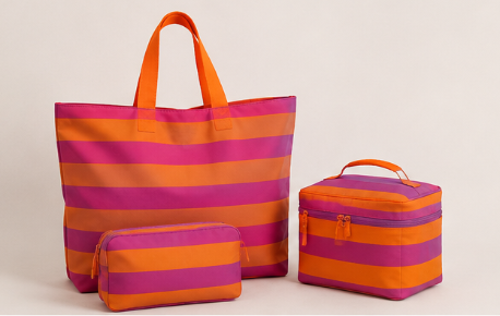Set de bolso de mano, neceser y bolsa grande con rayas horizontales en tonos rosa y naranja.