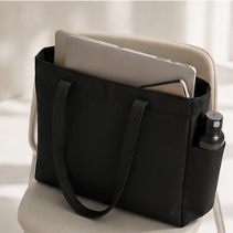 Bolso negro con portátil y botella de agua en el interior