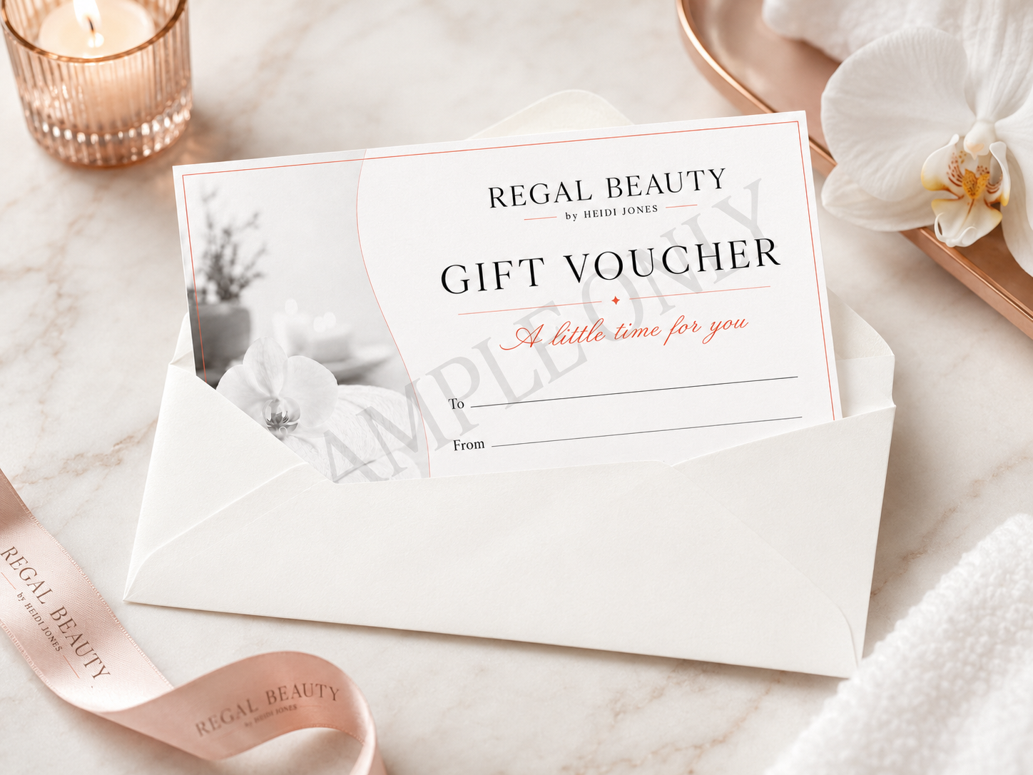 A gift voucher for Regal Beauty by Heidi Jones inside an envelope on a marble surface, surrounded by a pink ribbon, a pink candle holder, and a white orchid flower.