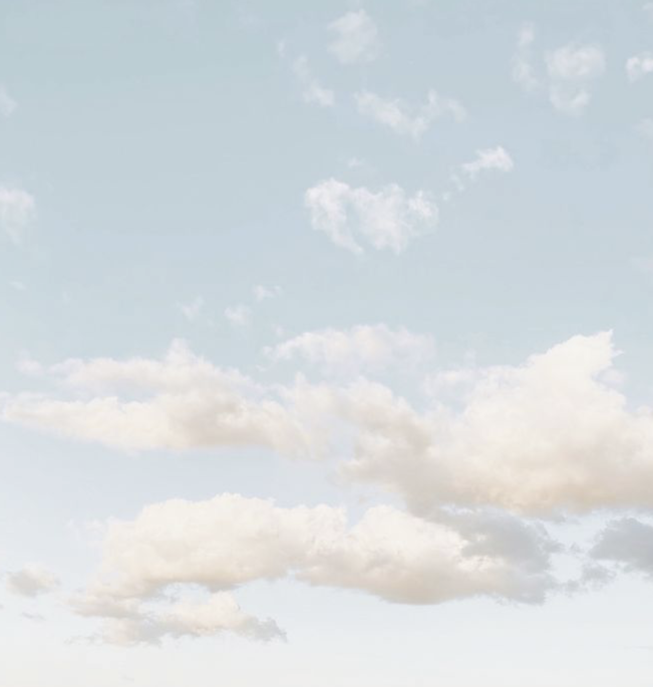 Light blue sky with scattered white and beige clouds.