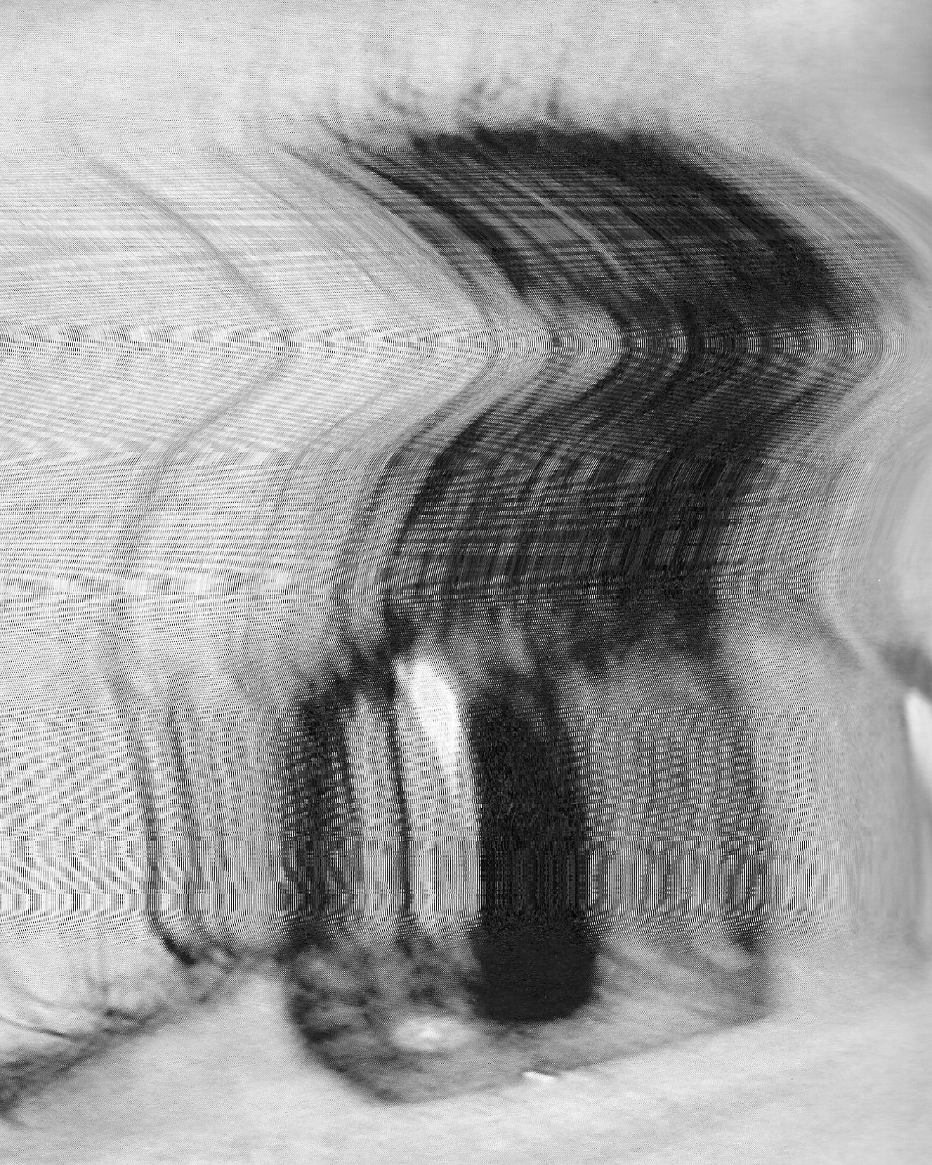 Black and white distorted image resembling a series of blurred, curved figures or objects with a ripple effect.