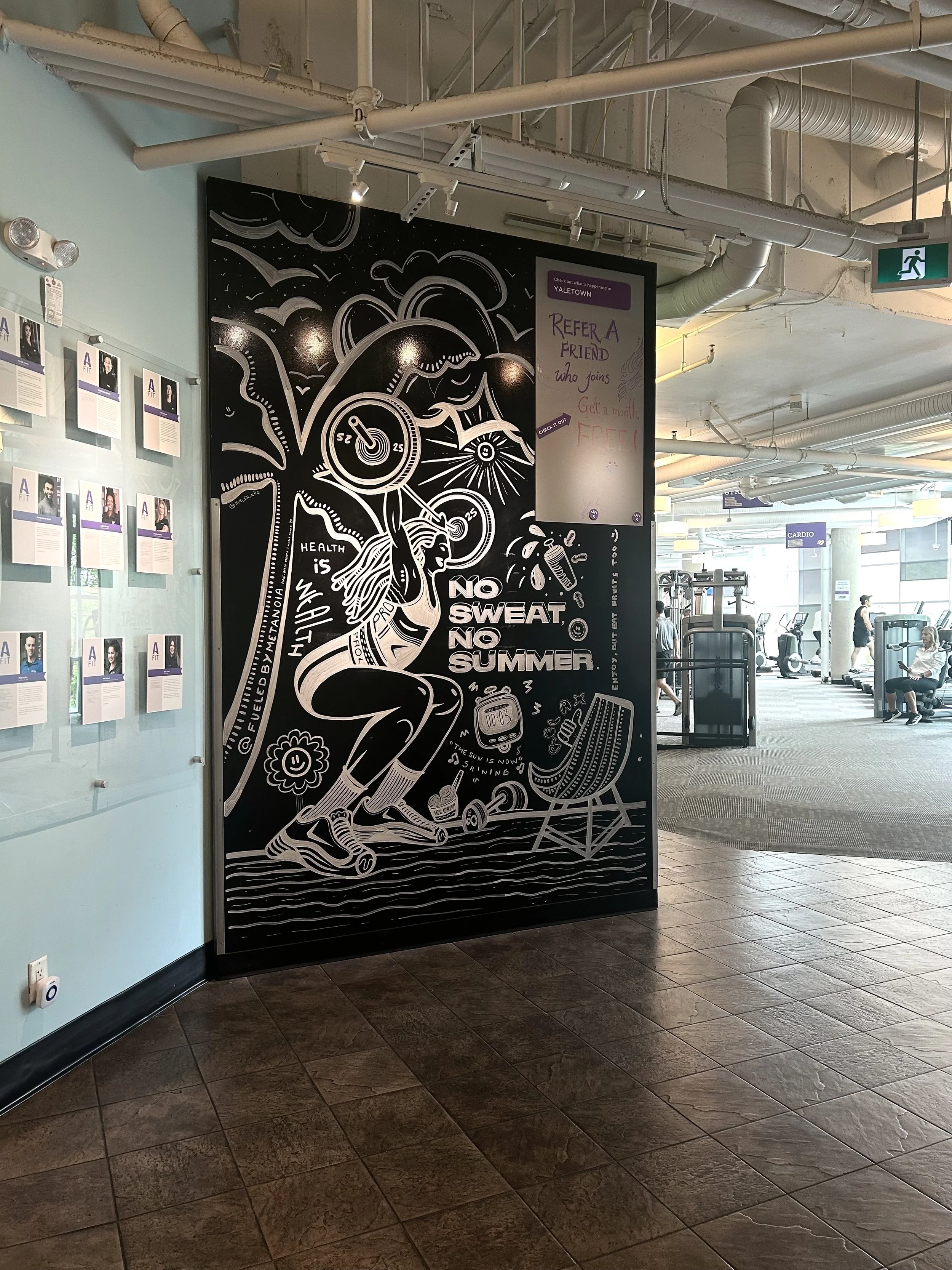 A black and white mural on a wall in a gym featuring a woman jogging, with motivational phrases like "No sweat, no summer". The mural includes illustrations of dumbbells, a stopwatch, a flower, and a ladder.