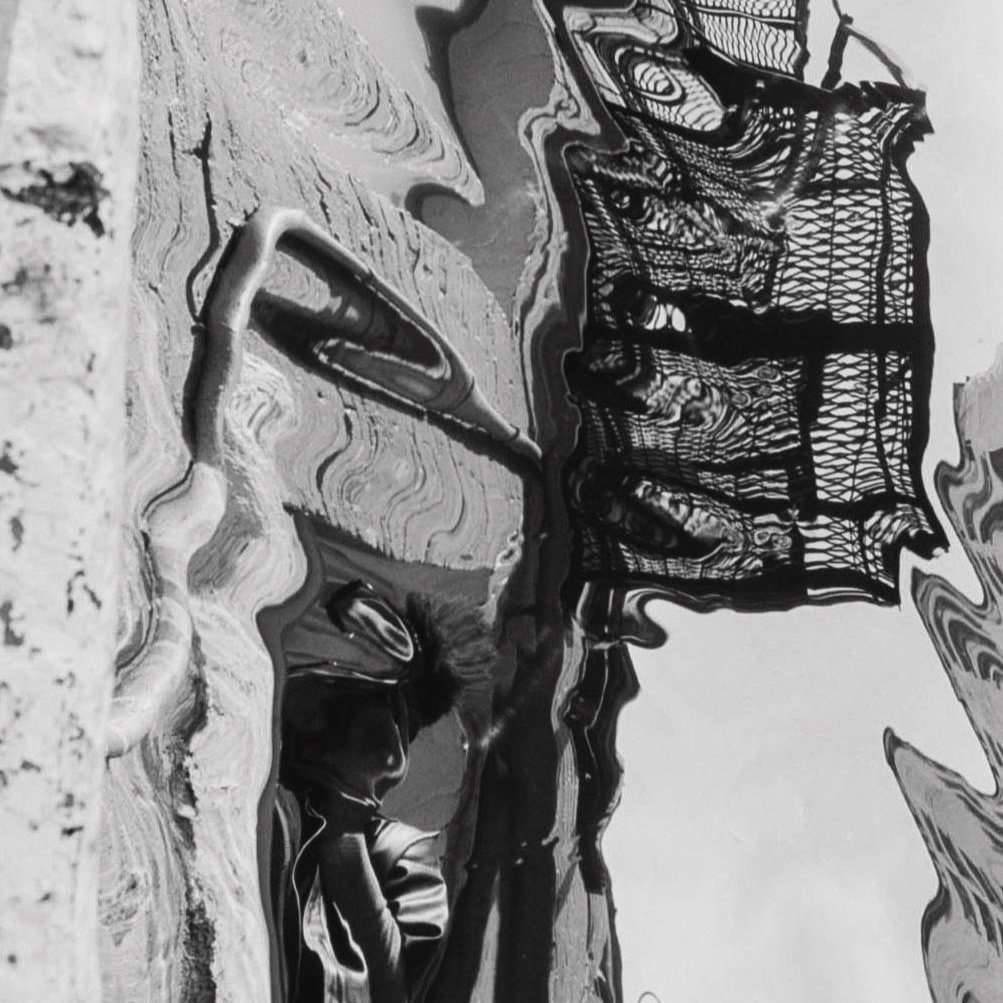 Distorted photograph of the photographer reflected on a mirrored paper