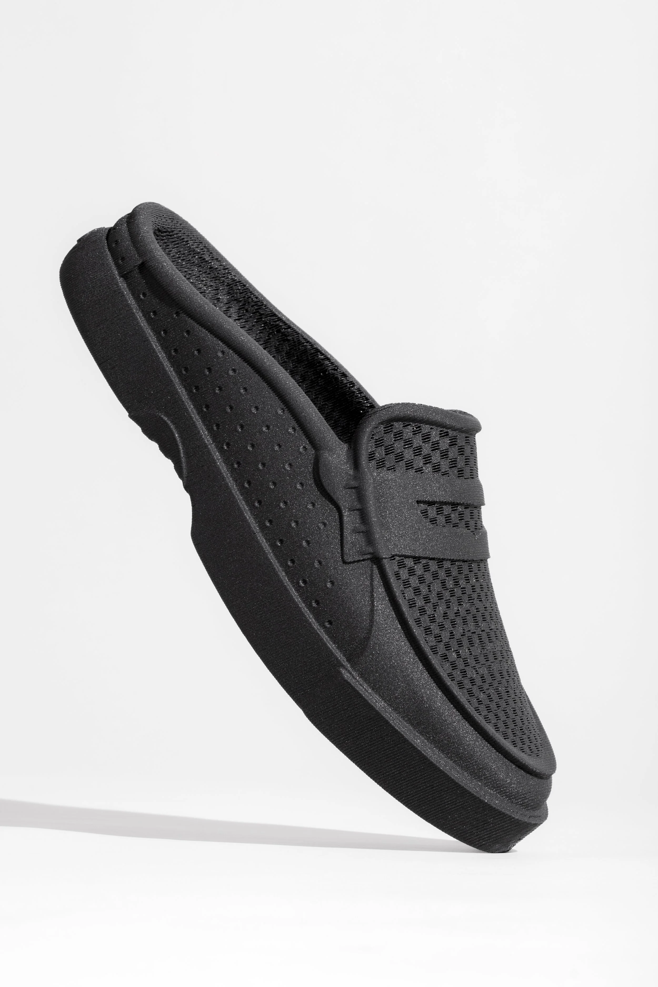 Close-up of a black athletic slide sandal with a cushioned sole and textured strap, set against a plain white background.
