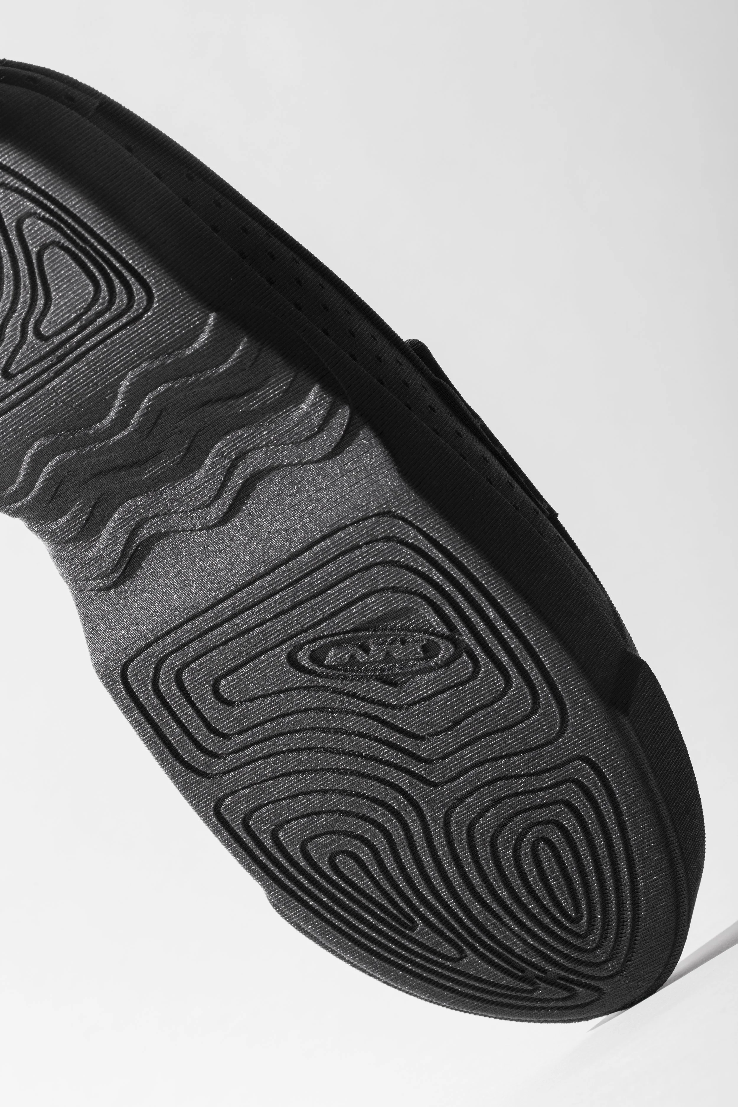 Close-up of a black sole of a shoe on a light background.