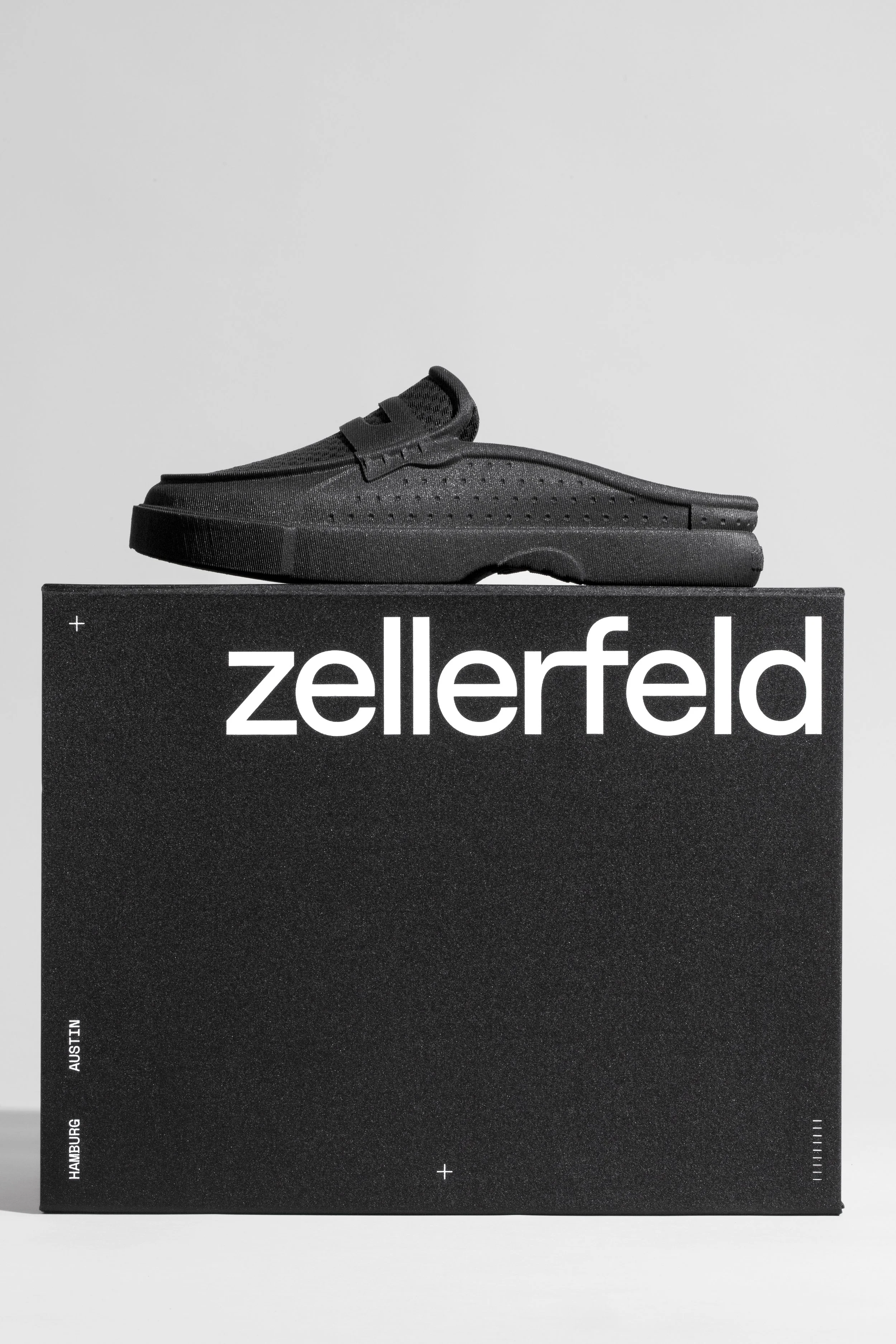 Black sneaker display on a black box with white text 'zellerfeld' and a light gray background.