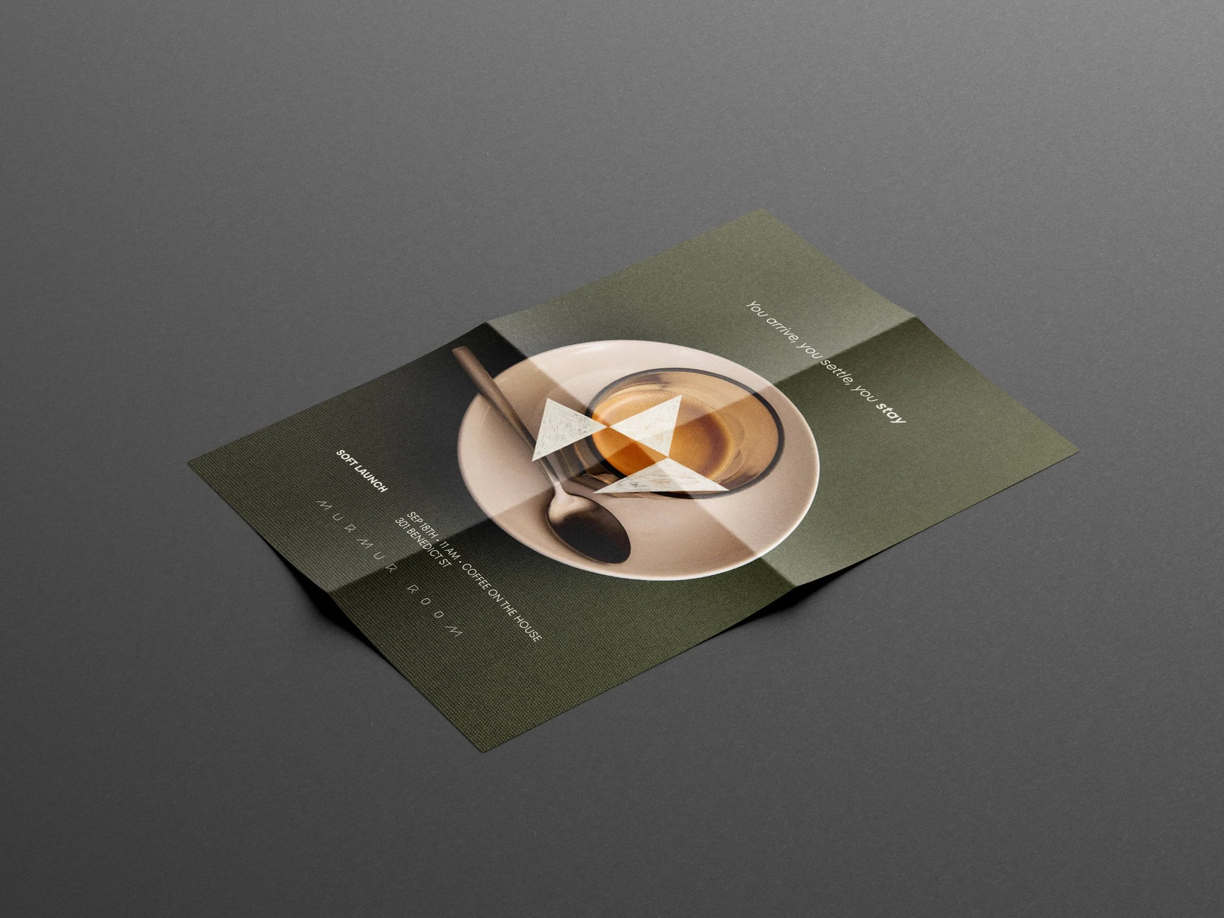 A flyer on a gray surface promoting a coffeehouse event, featuring an image of a cup of coffee and text about the event details.
