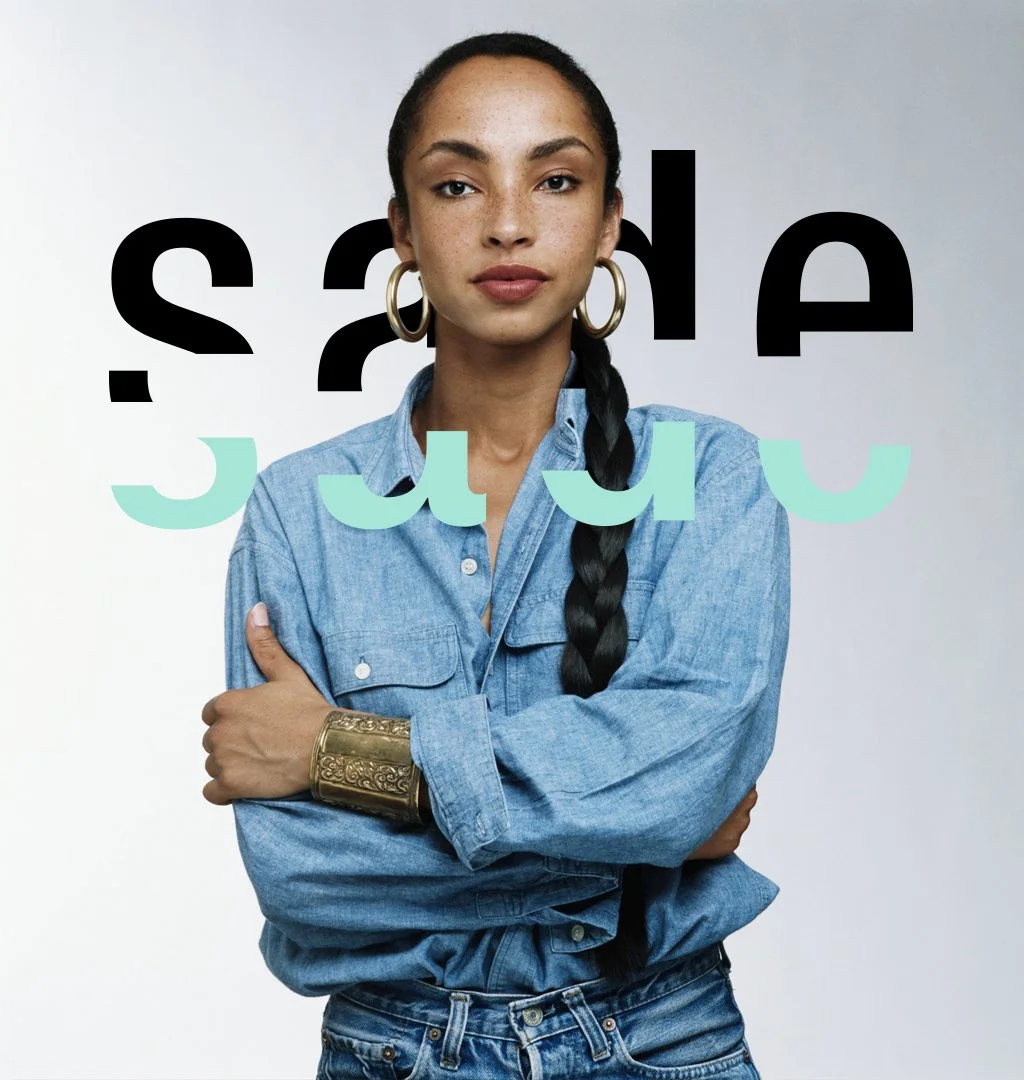 A woman with dark hair in a braid, wearing large hoop earrings, a denim shirt, and a gold cuff bracelet, standing with arms crossed in front of a white background with overlapping black and mint green text that reads 'Sade'.