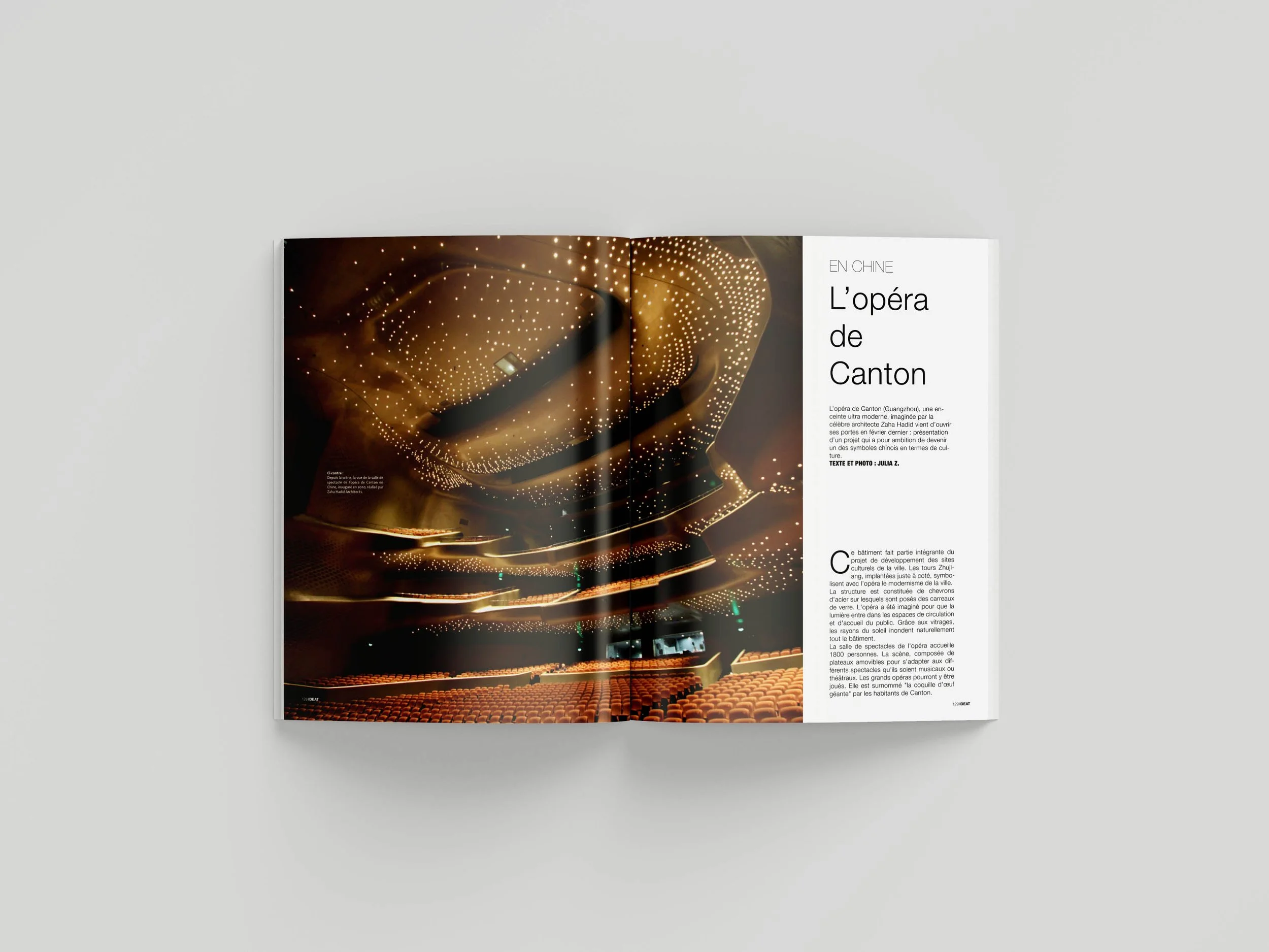 An open magazine featuring an article about the Opera of Canton, showcasing an interior photo of the stage with a modern, illuminated ceiling design and empty auditorium seats.